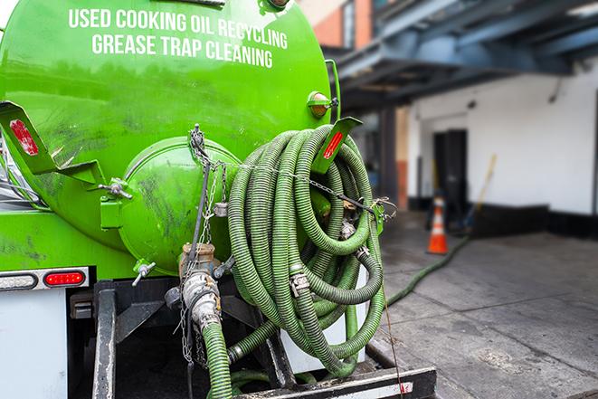 a technician pumping a grease trap in a commercial building in Drexel Hill